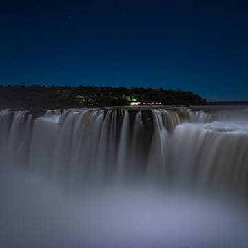 a waterfall with a forest in the background