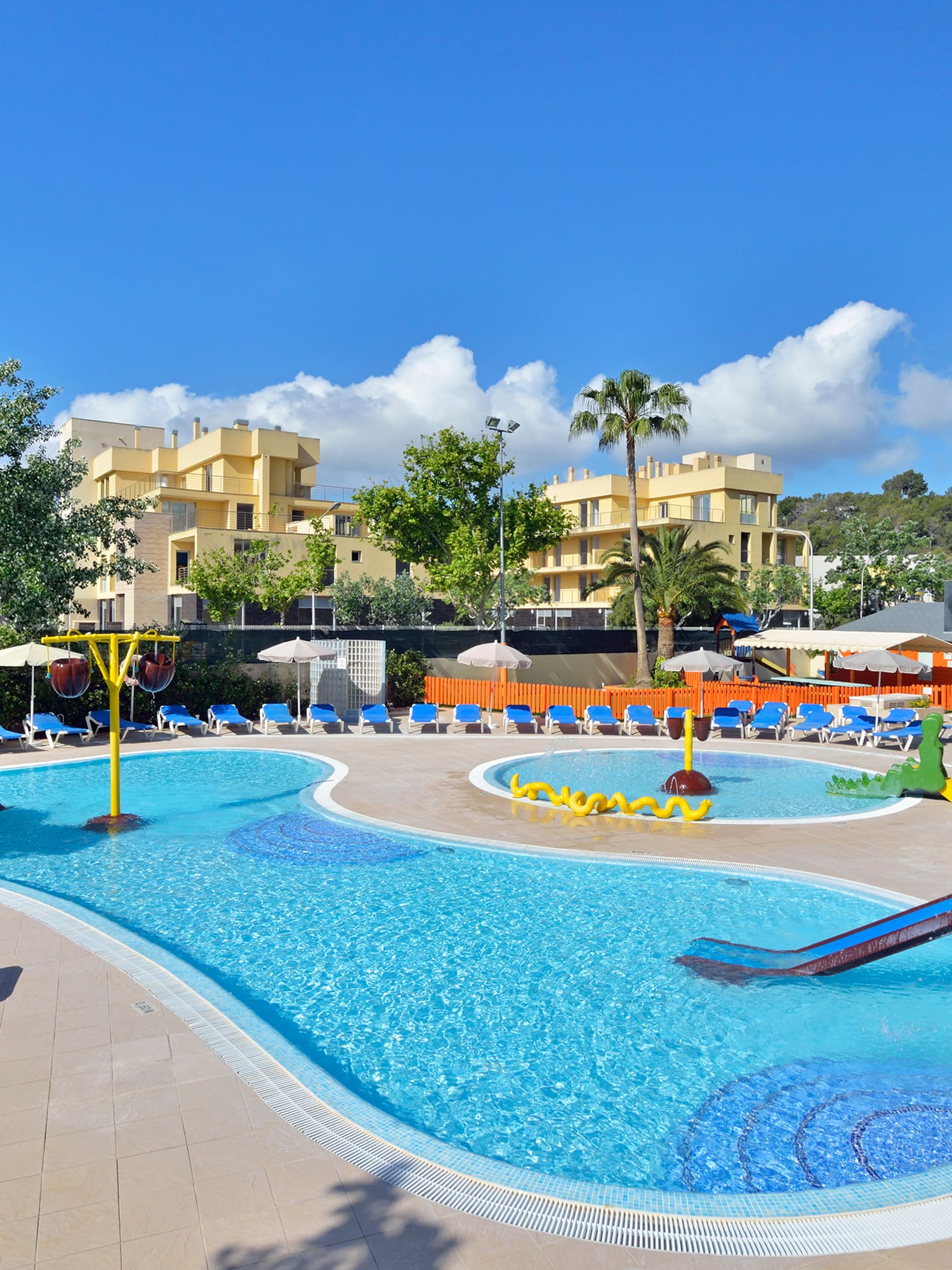 a pool with a slide and chairs