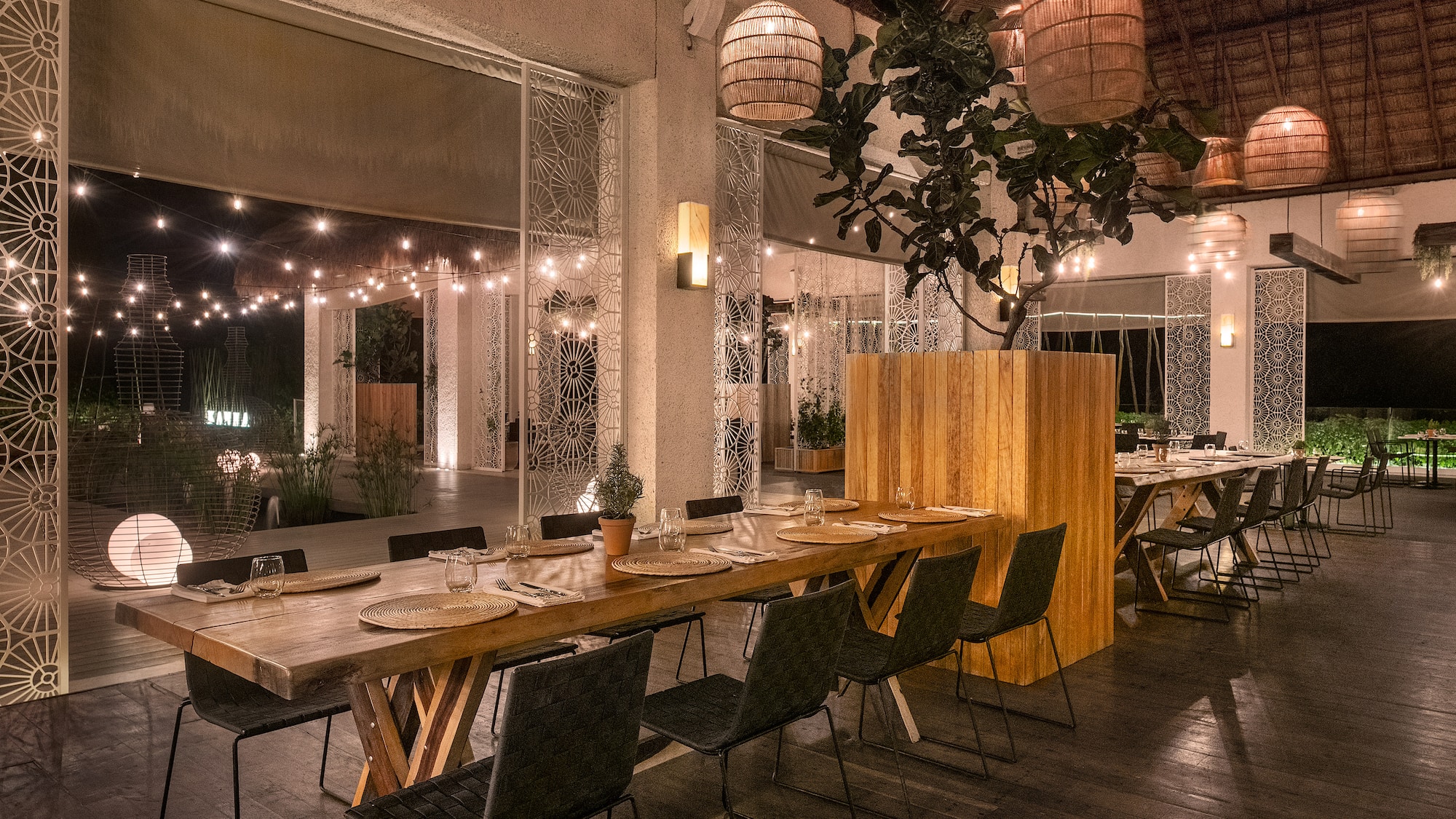 a long table with plates and chairs in a room with lights