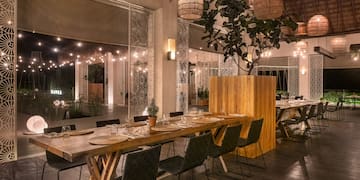 a long table with plates and chairs in a room with lights