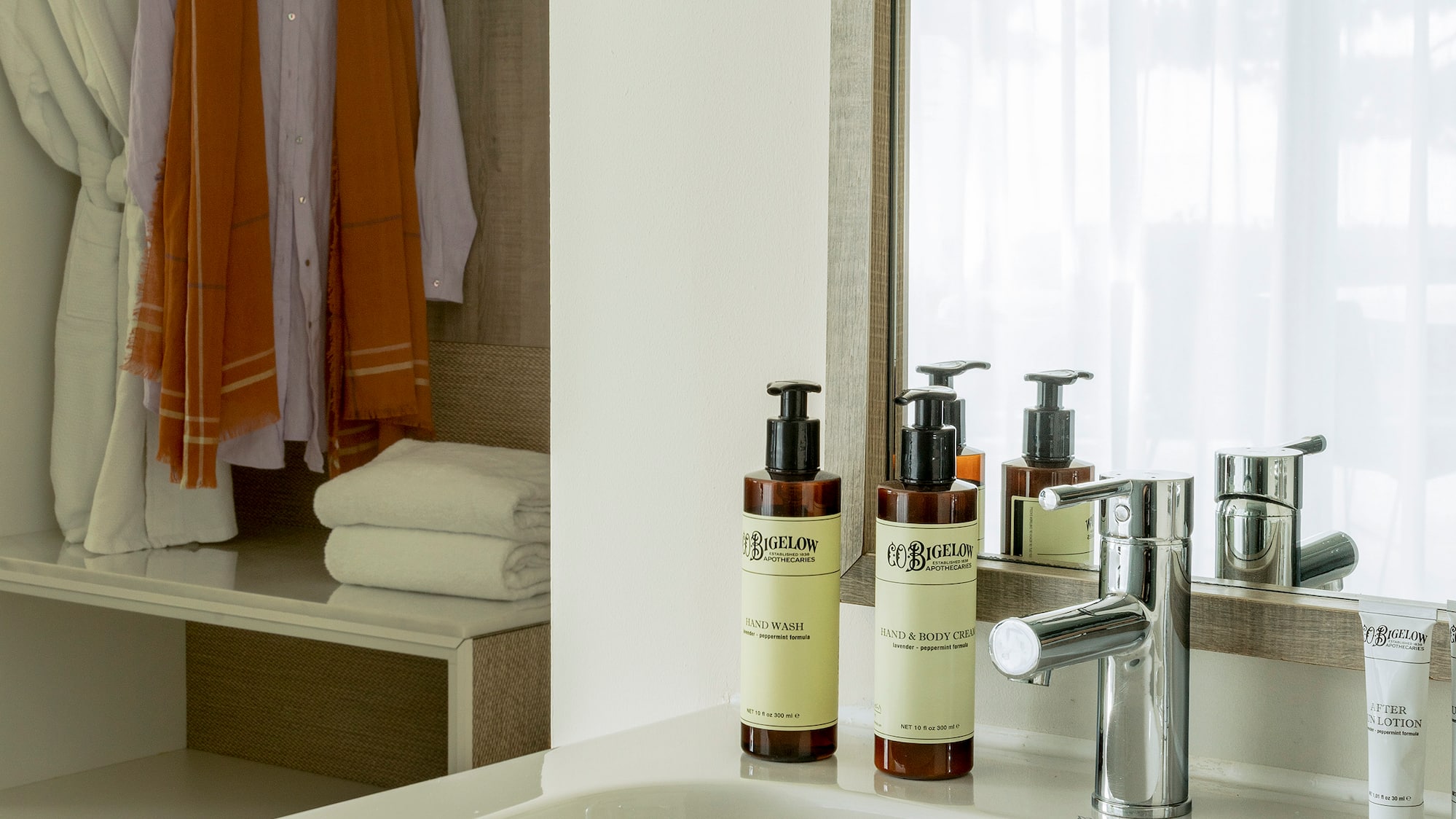 a bathroom sink with a mirror and towels