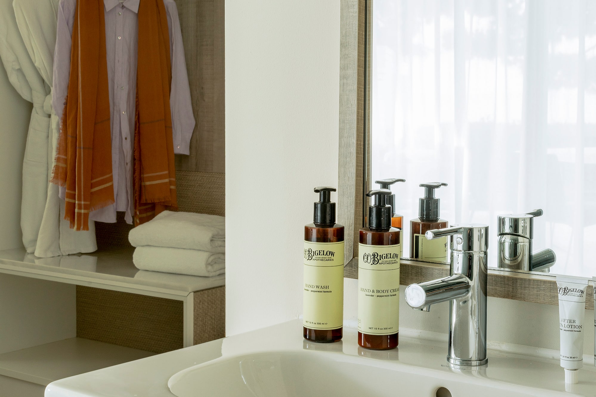 a bathroom sink with a mirror and towels