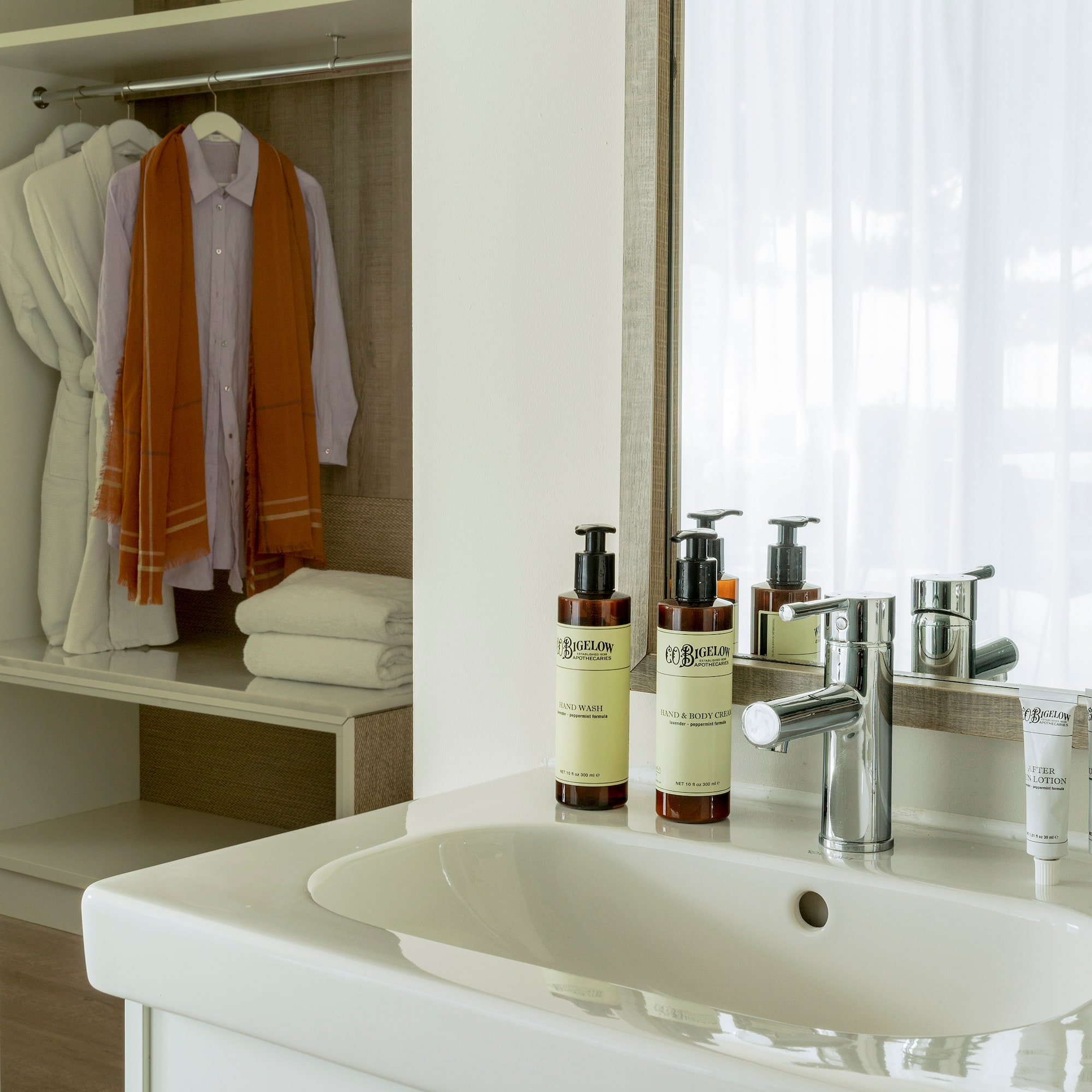 a bathroom sink with a mirror and towels