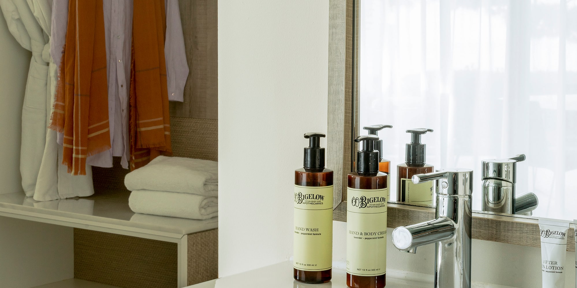 a bathroom sink with a mirror and towels