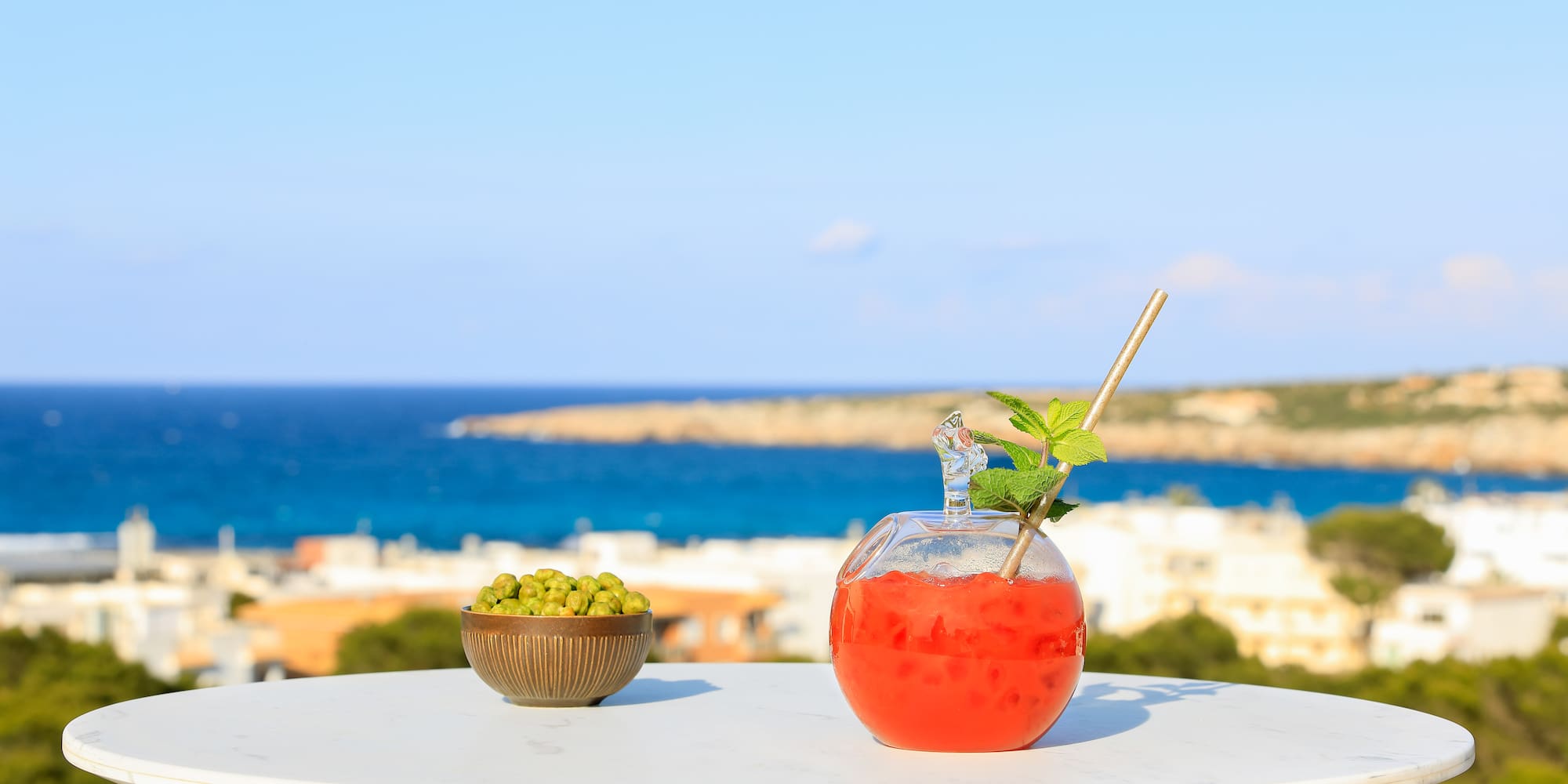 a bowl of fruit and a drink on a table