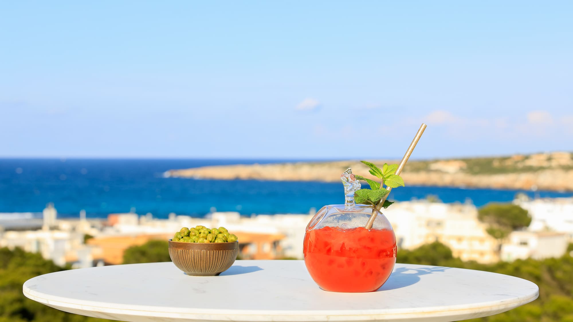a bowl of fruit and a drink on a table