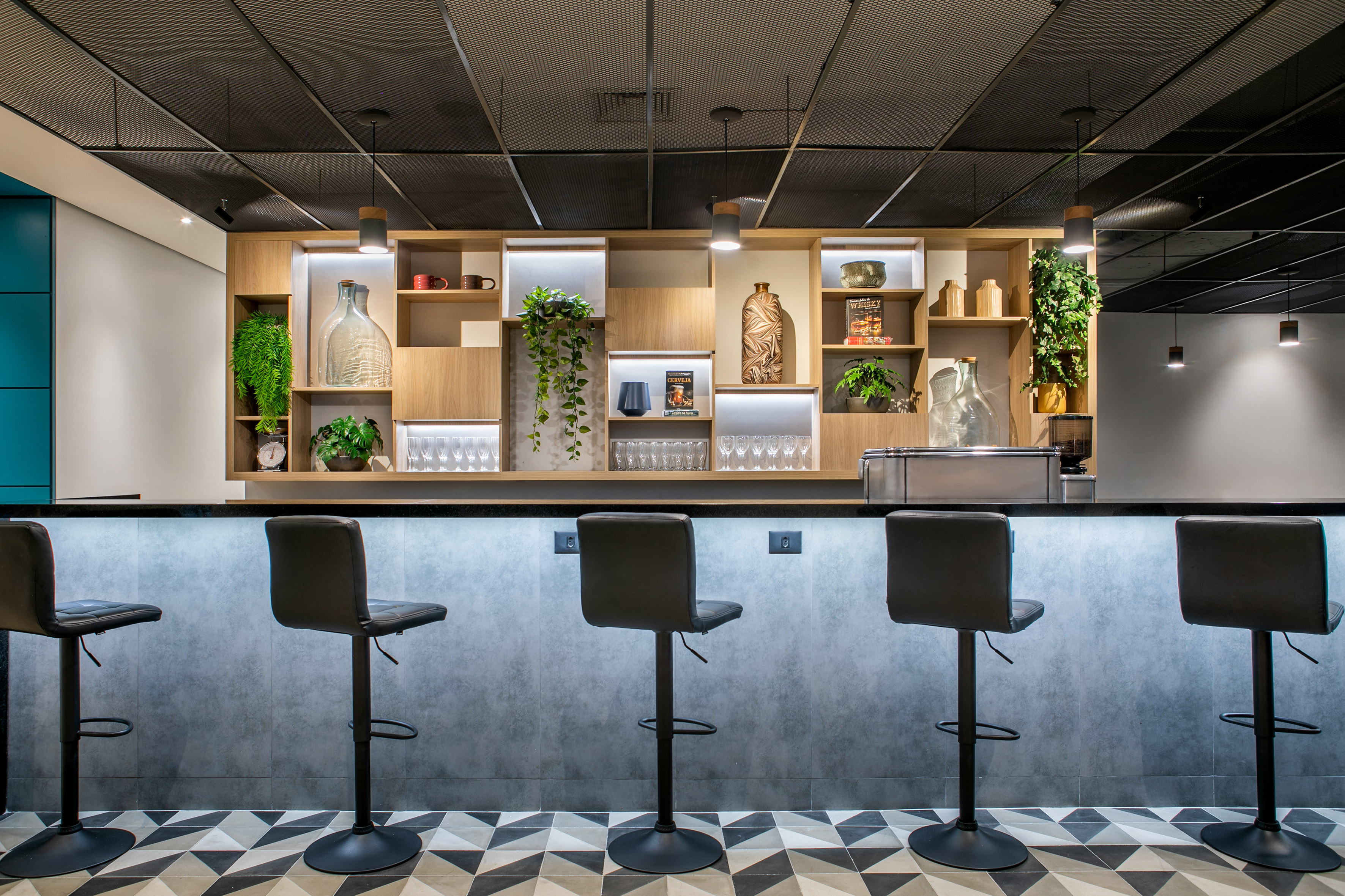 Modern bar design with black stools, illuminated shelves, and patterned floor.