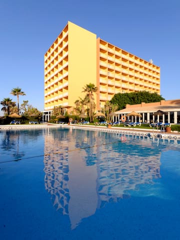 a large building with a pool in front of it.