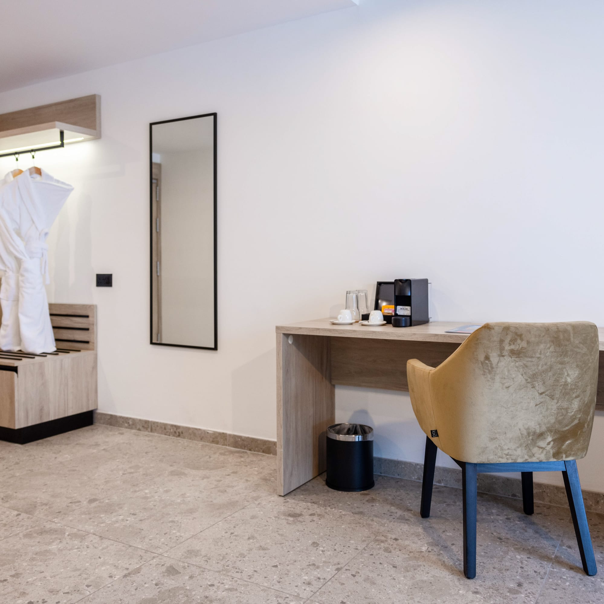 a room with a white robe and a desk and a mirror