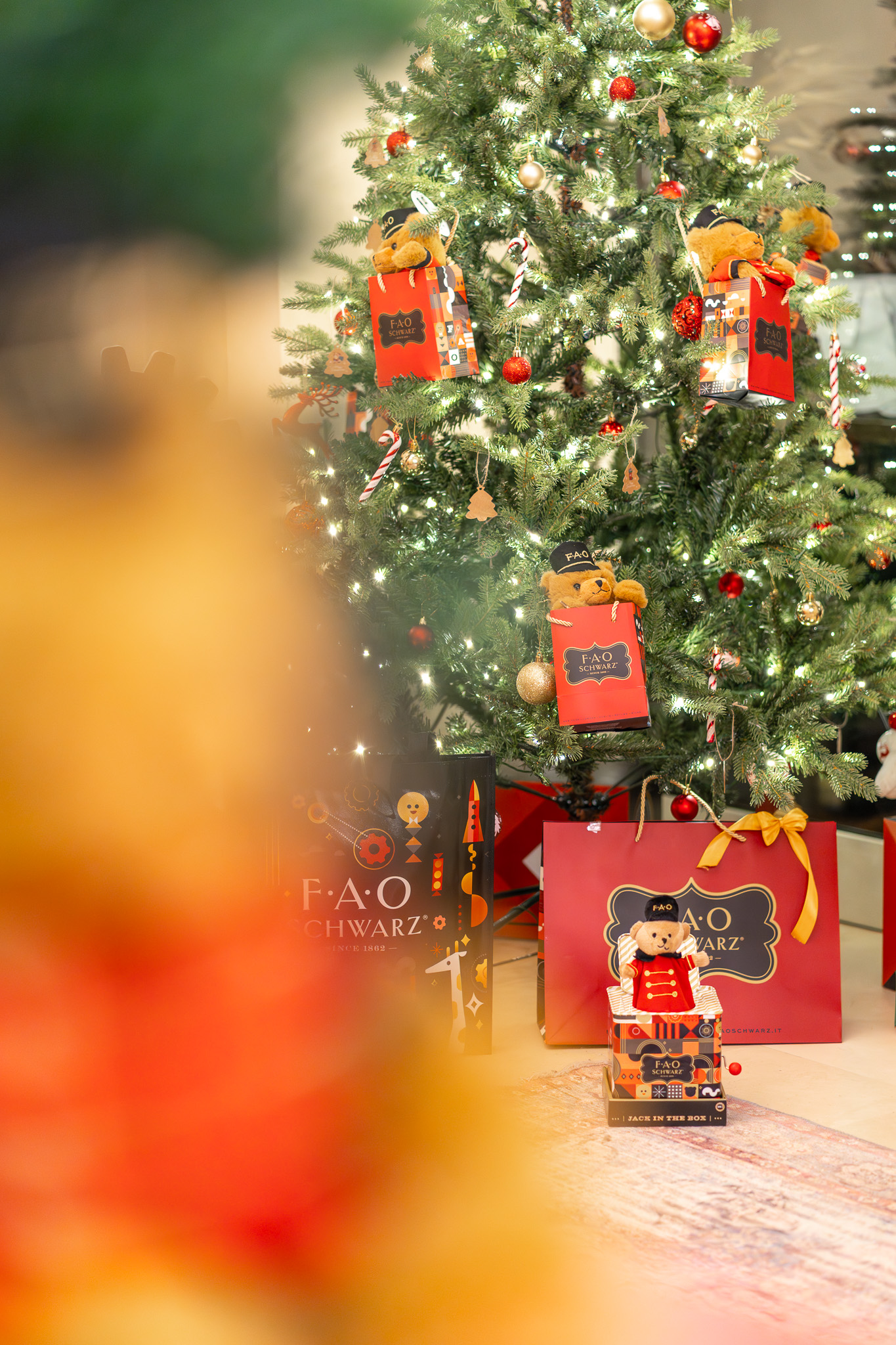 Festive Christmas tree adorned with FAO Schwarz teddy bears, gifts, and ornaments.