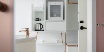 a white shelf with a microwave and a sink
