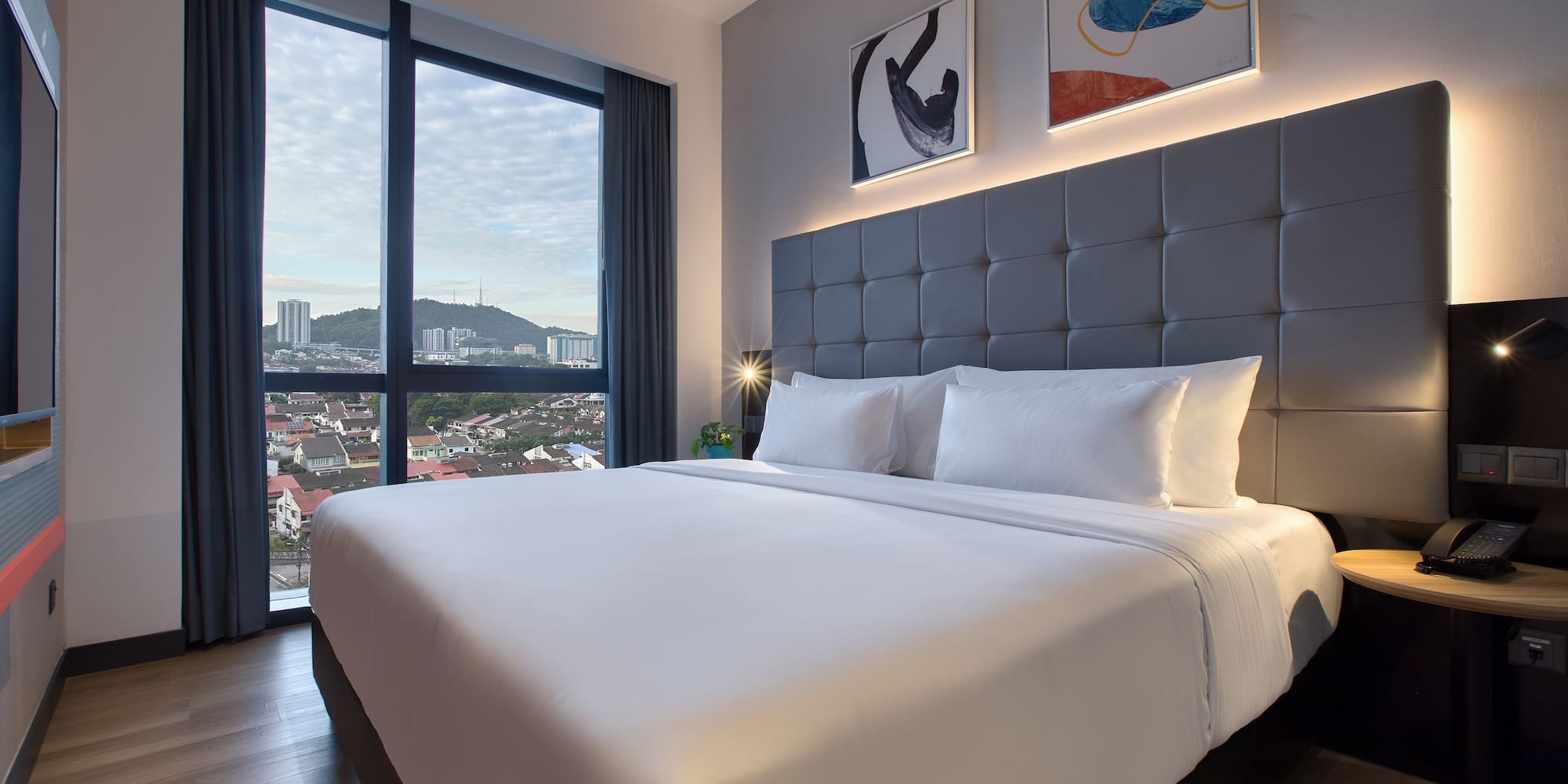 a bed with a large headboard and a lamp