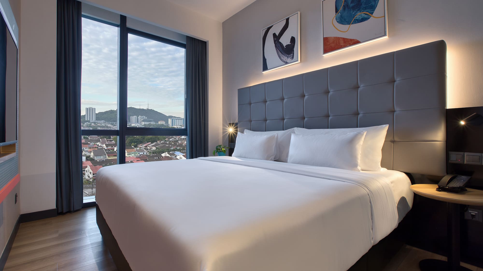 a bed with a large headboard and a lamp