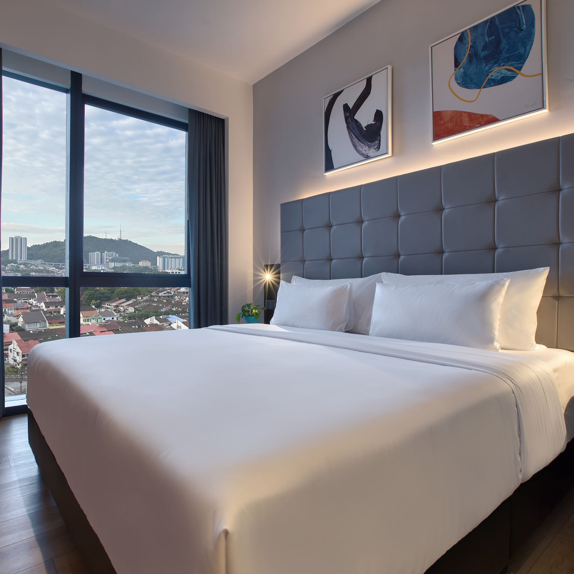 a bed with a large headboard and a lamp