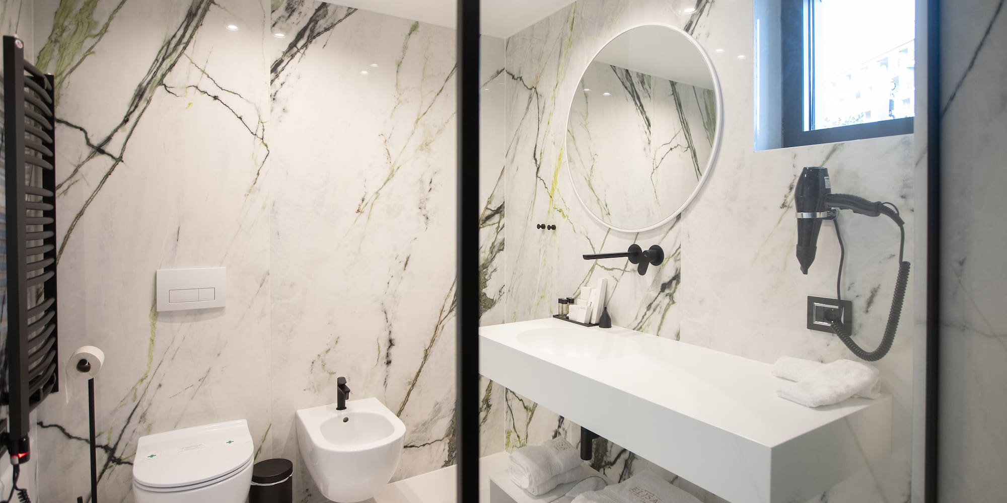 a bathroom with marble walls and a sink and toilet