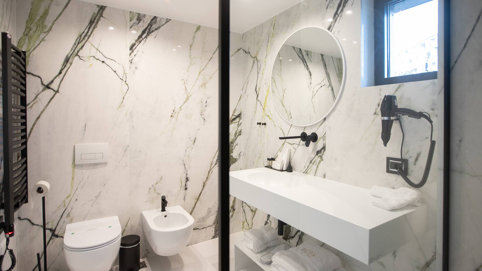 a bathroom with marble walls and a sink and toilet