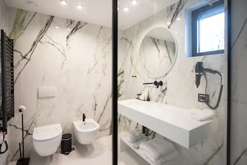 a bathroom with marble walls and a sink and toilet