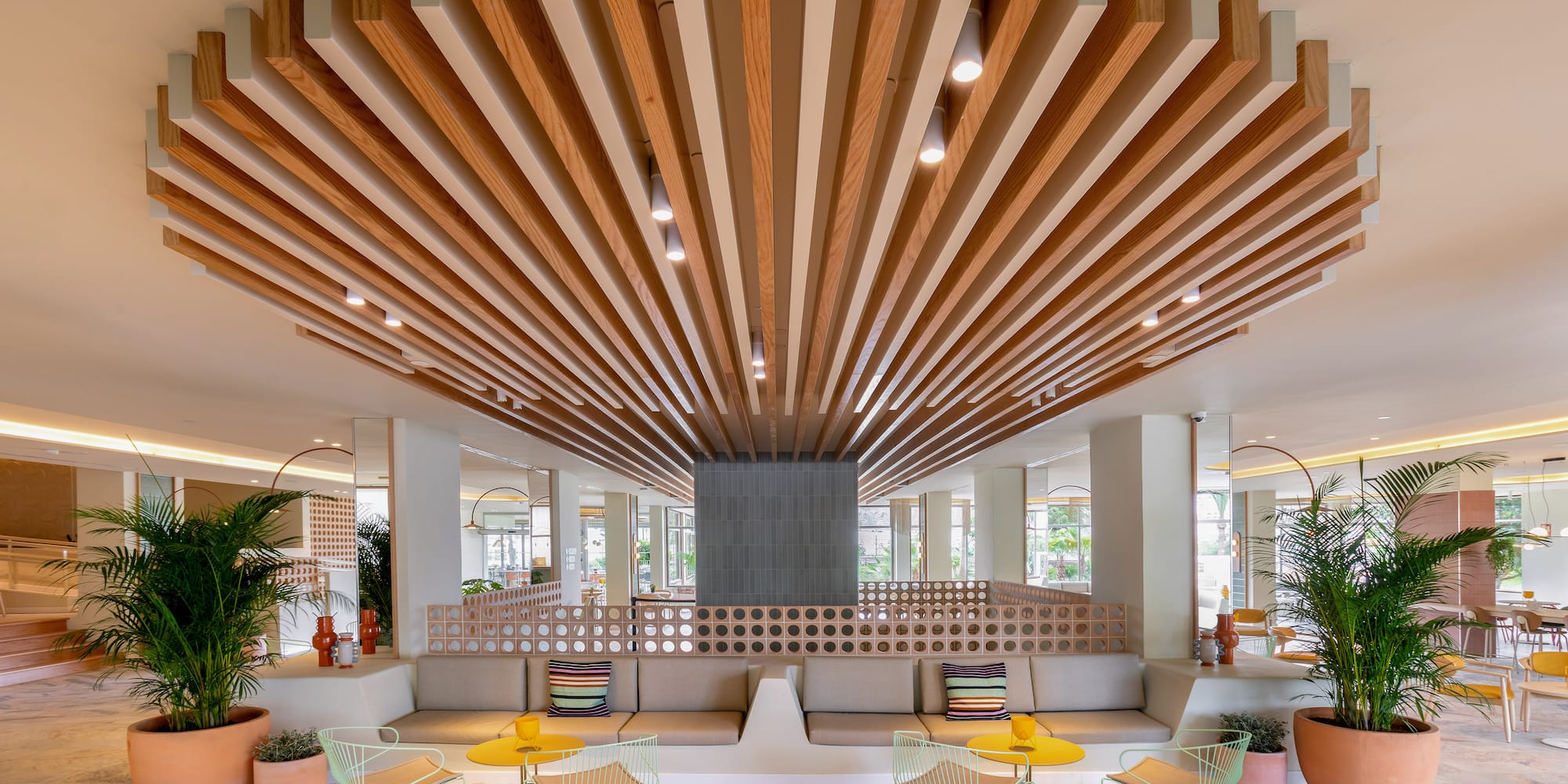 a room with a large ceiling and a couch and chairs