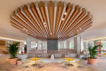 a room with a large ceiling and a couch and chairs