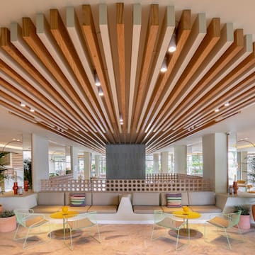 a room with a large ceiling and a couch and chairs