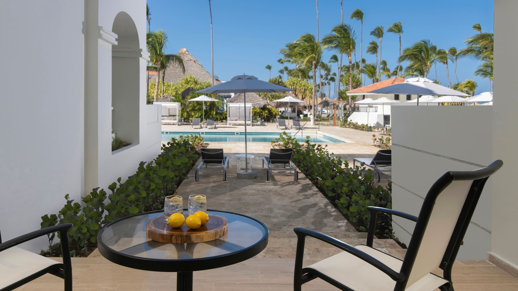 a table with two lemons on it and a pool in the background