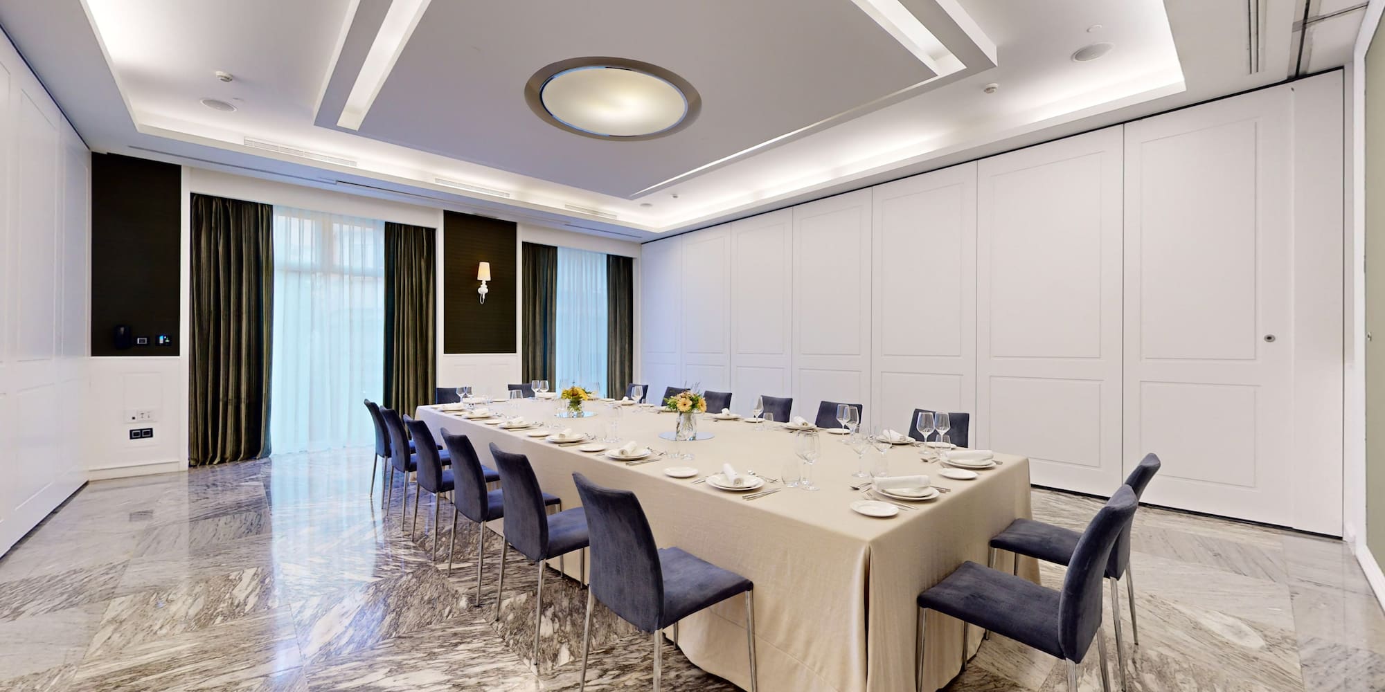 a large table with blue chairs and a white tablecloth
