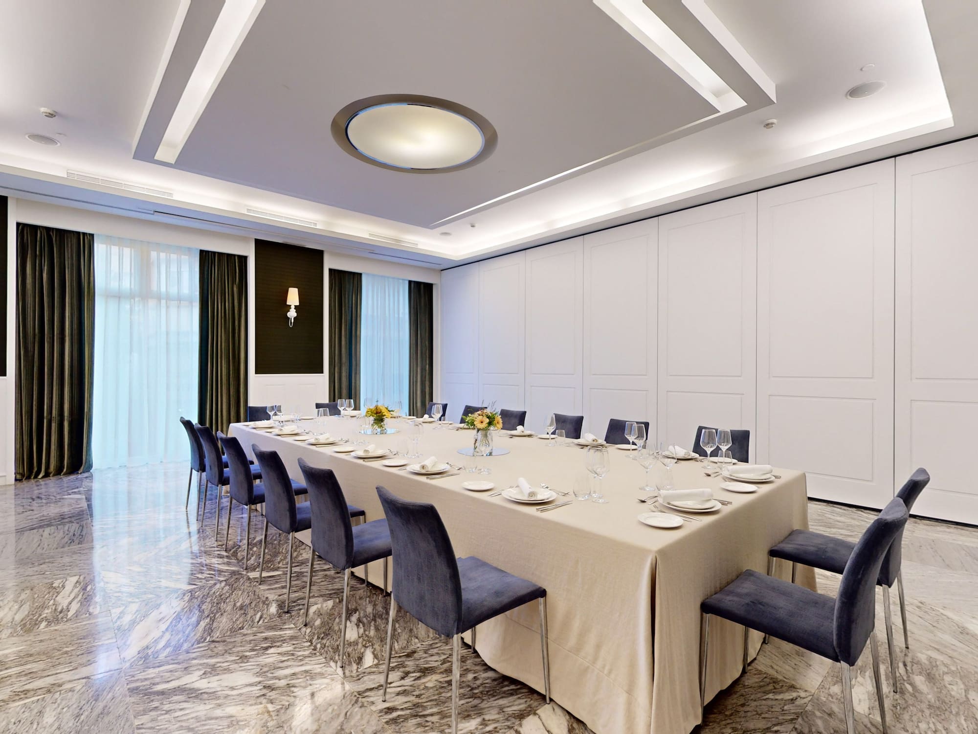 a large table with blue chairs and a white tablecloth