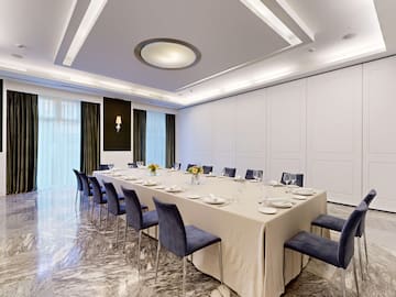 a large table with blue chairs and a white tablecloth