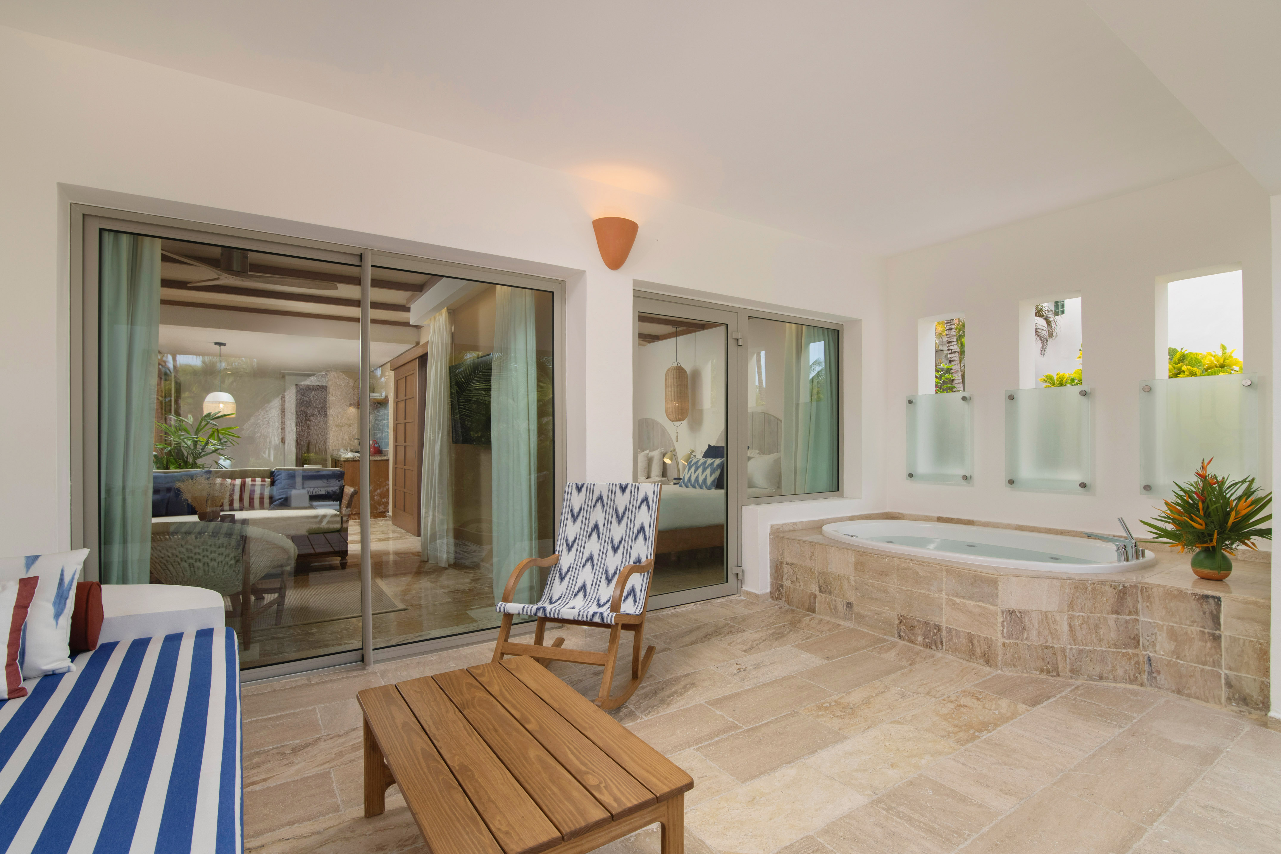 Luxury tropical patio with private hot tub, rocking chair, and suite access.