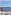 Ocean view balcony with wooden patio furniture, book, and sunglasses.