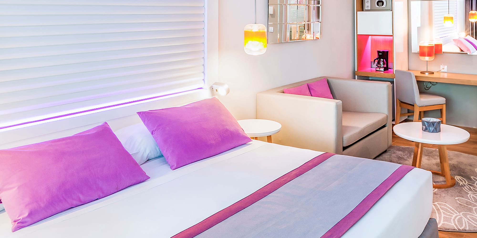 a bed with purple pillows and a couch in a room