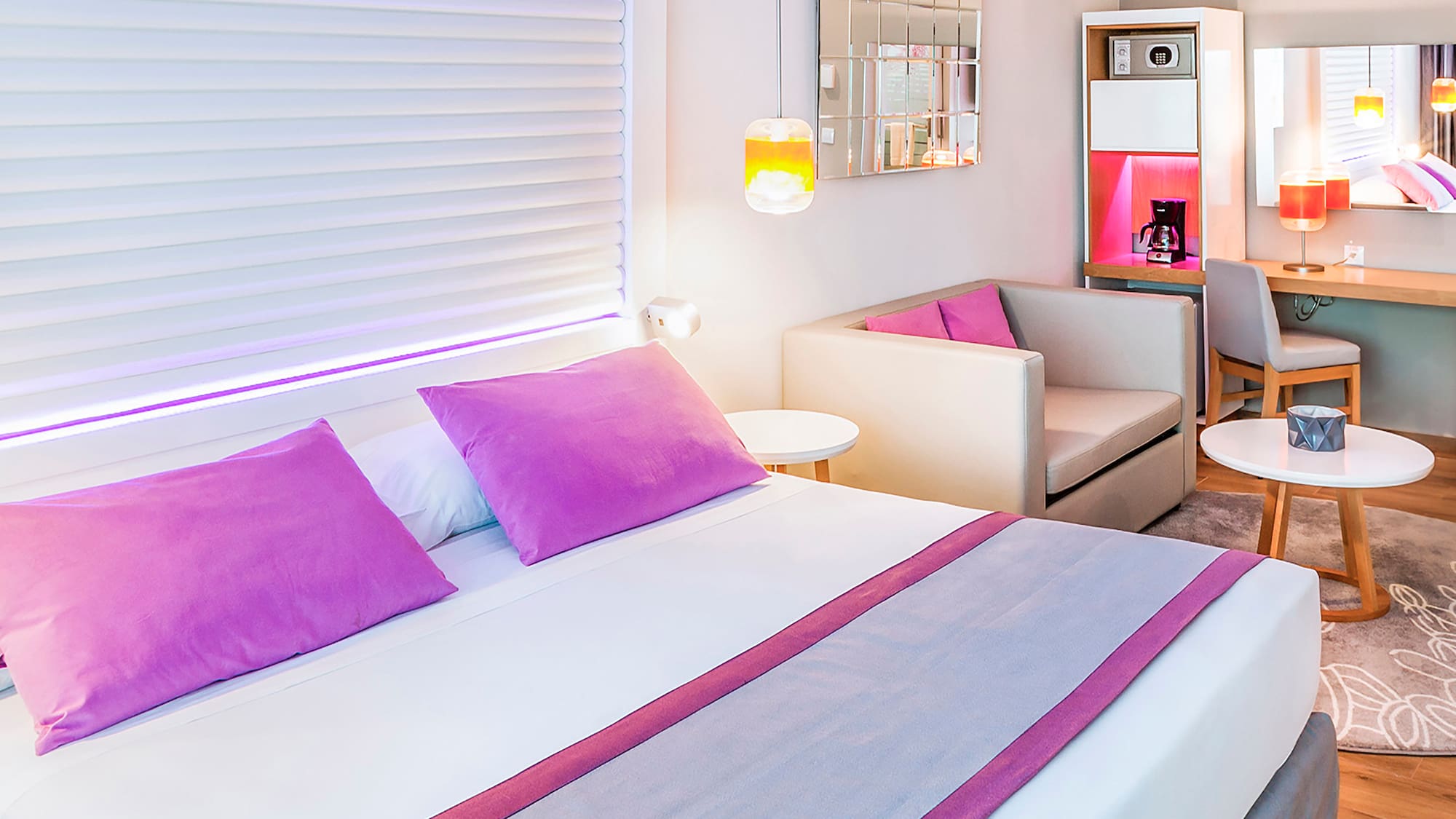 a bed with purple pillows and a couch in a room