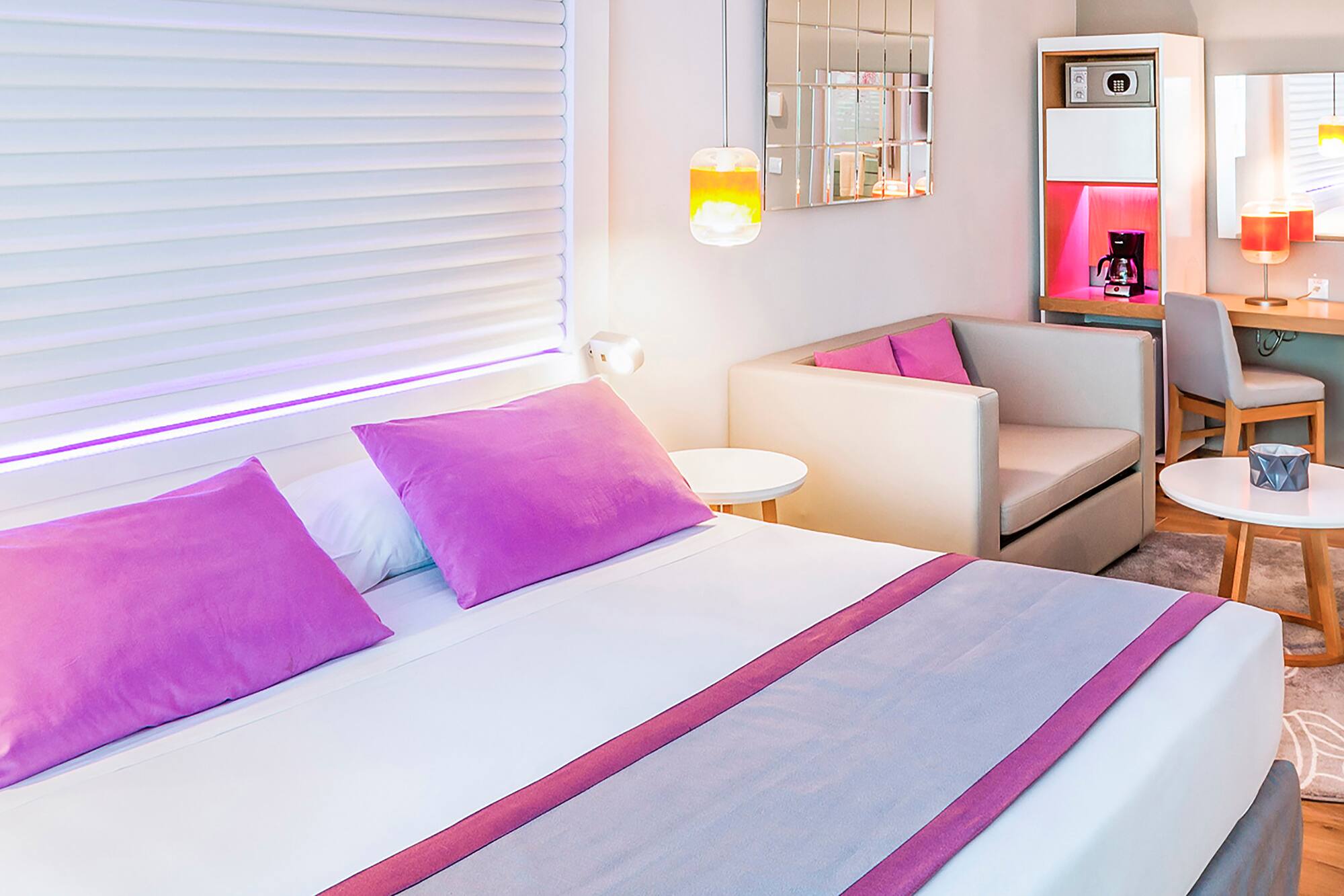 a bed with purple pillows and a couch in a room