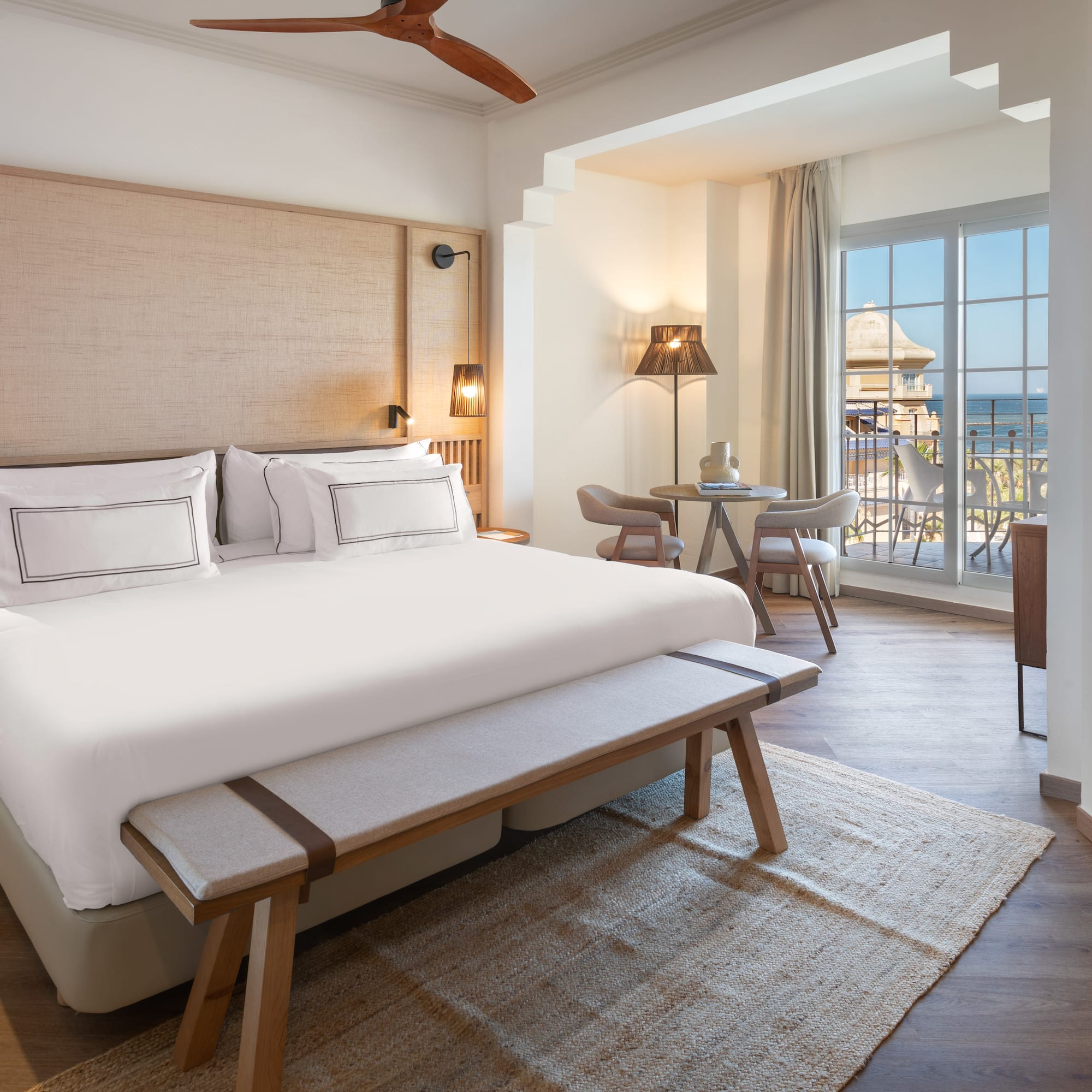 a room with a bed and a table and chairs