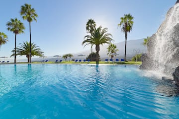 a pool with a fountain and palm trees