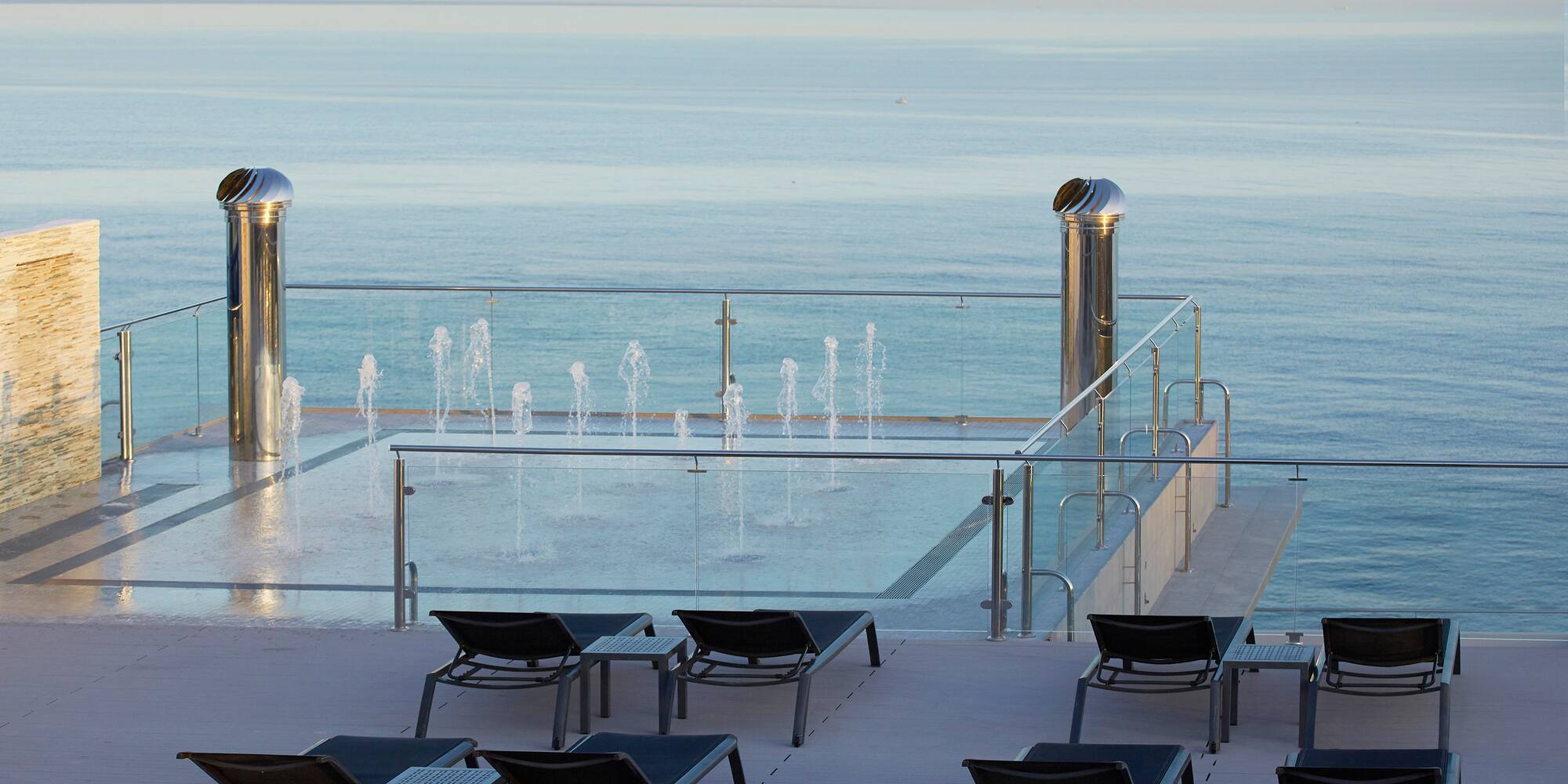a pool with water fountains and chairs
