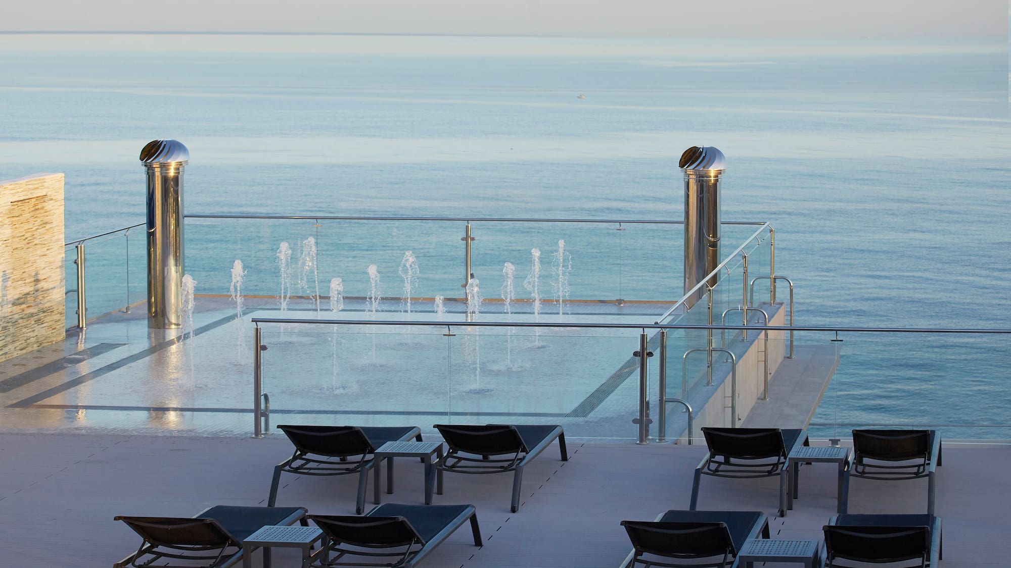 a pool with water fountains and chairs