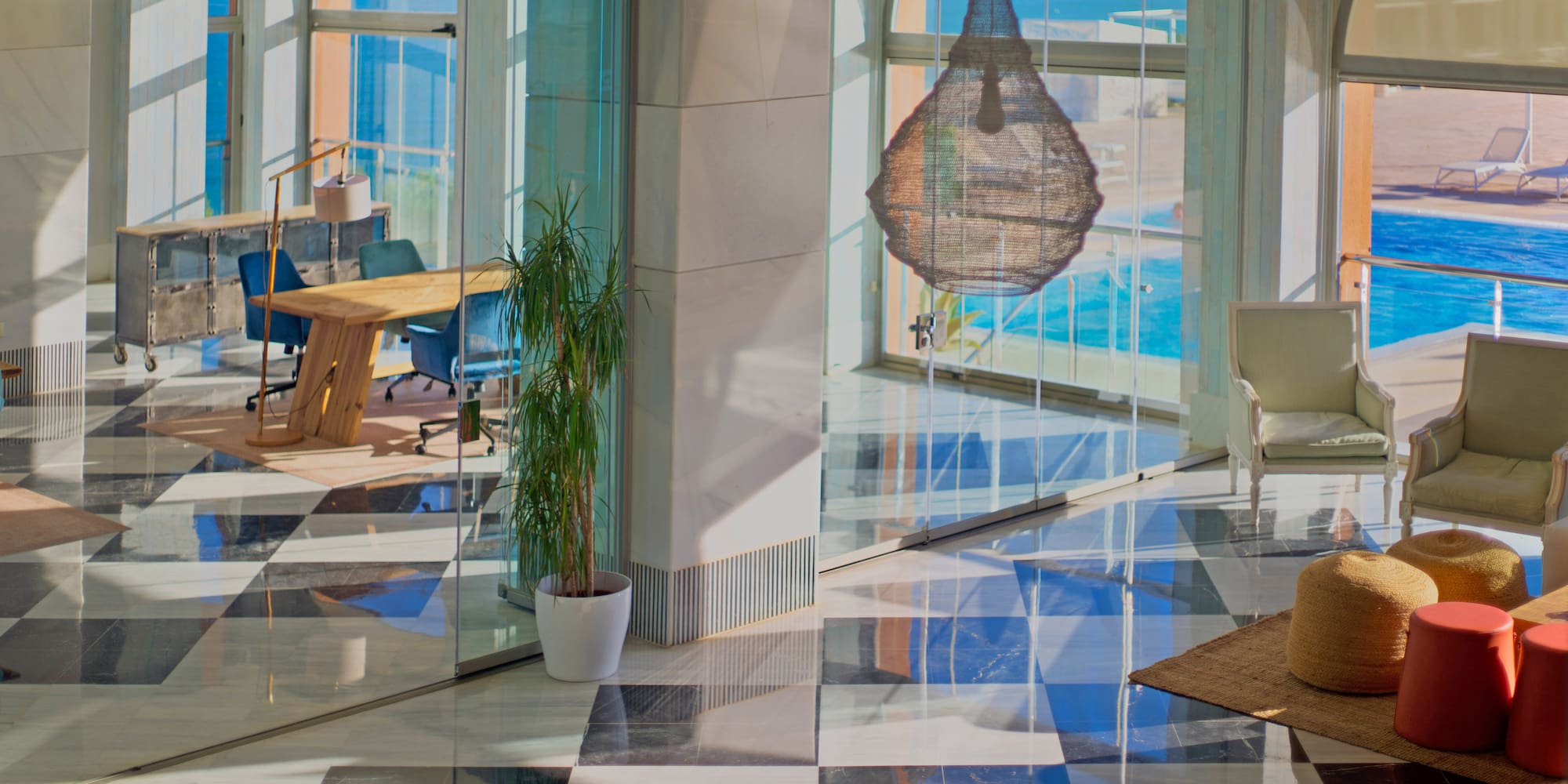 a glass wall with a table and chairs in front of a large window