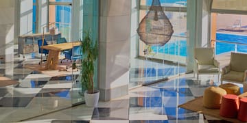 a glass wall with a table and chairs in front of a large window
