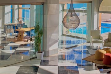 a glass wall with a table and chairs in front of a large window