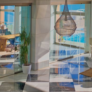 a glass wall with a table and chairs in front of a large window