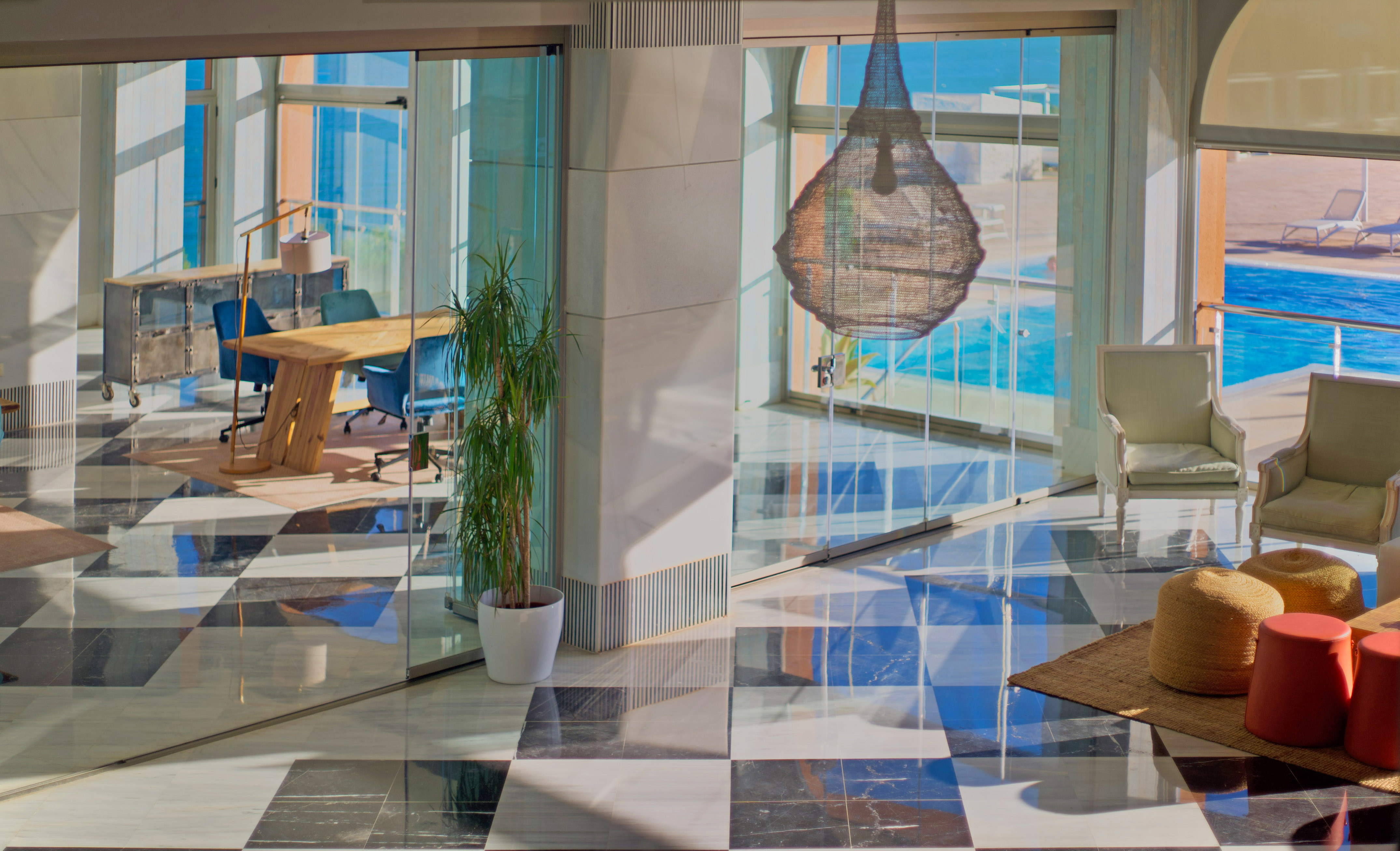 a glass wall with a table and chairs in front of a large window