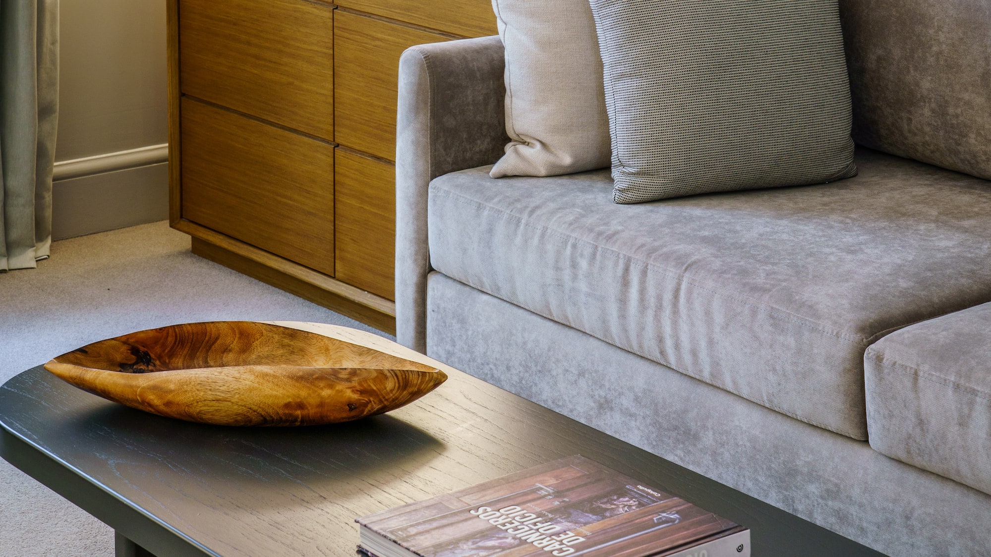 a couch with a wood bowl on top of a coffee table