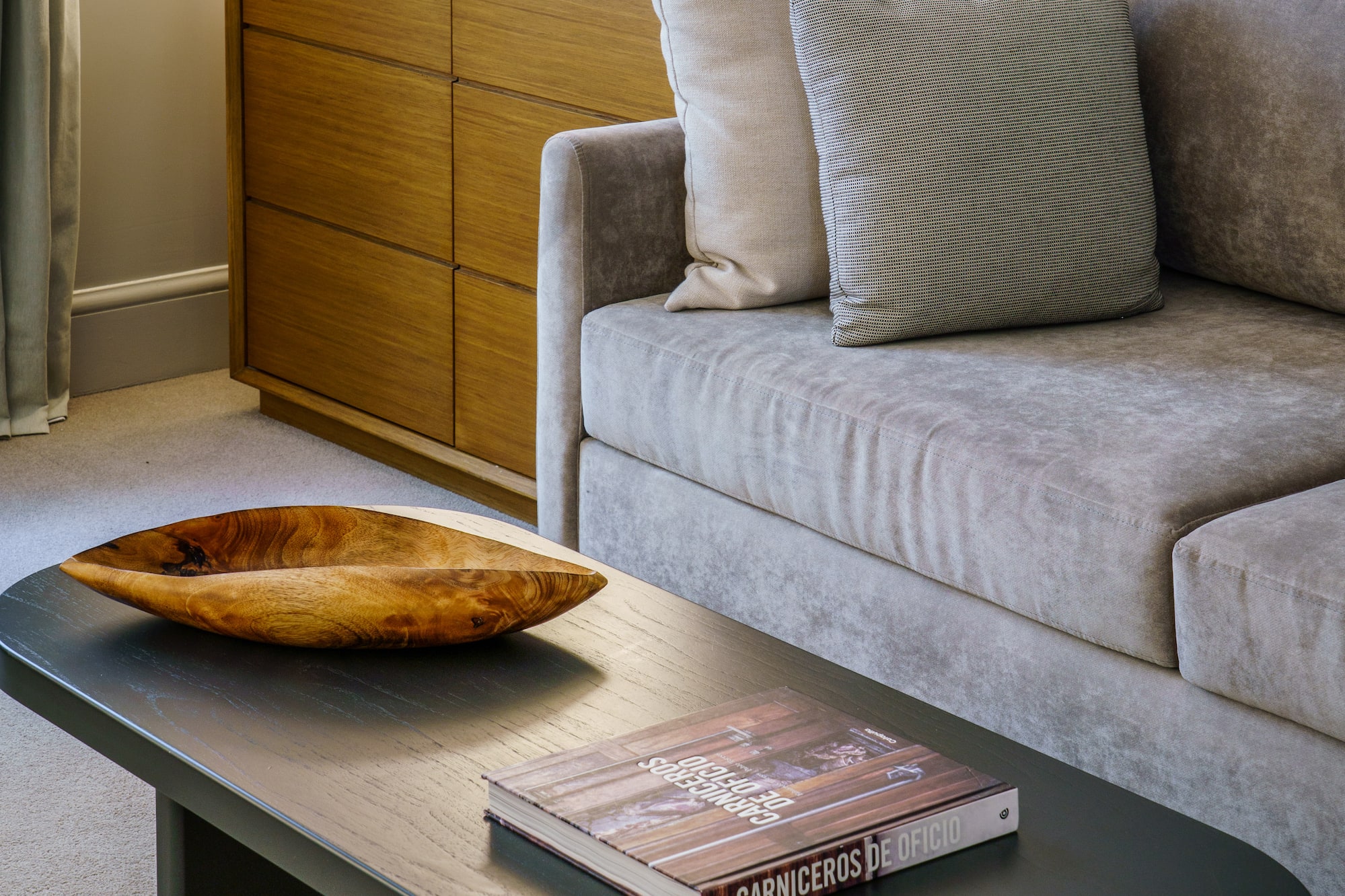 a couch with a wood bowl on top of a coffee table