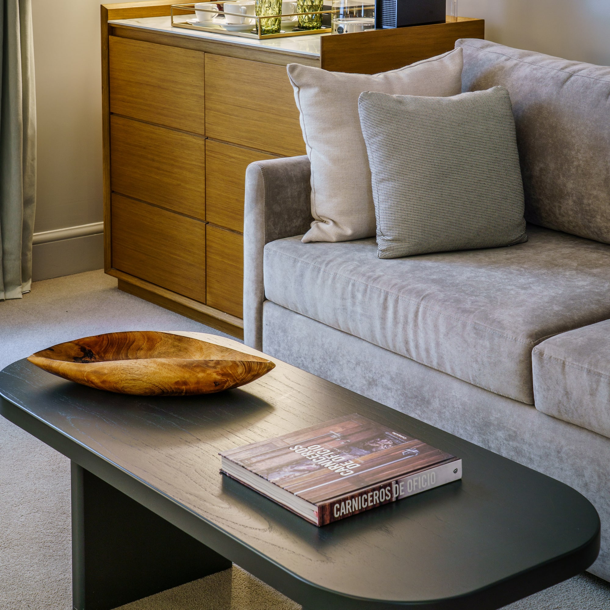 a couch with a wood bowl on top of a coffee table