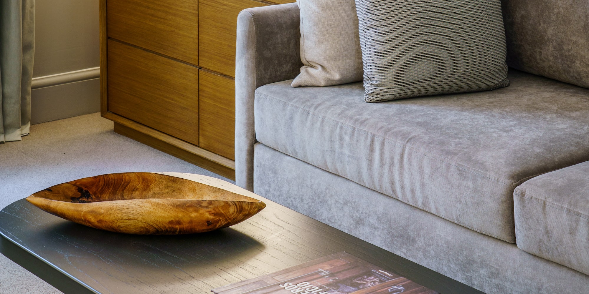 a couch with a wood bowl on top of a coffee table
