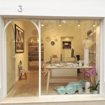 a window of a store with a table and plates