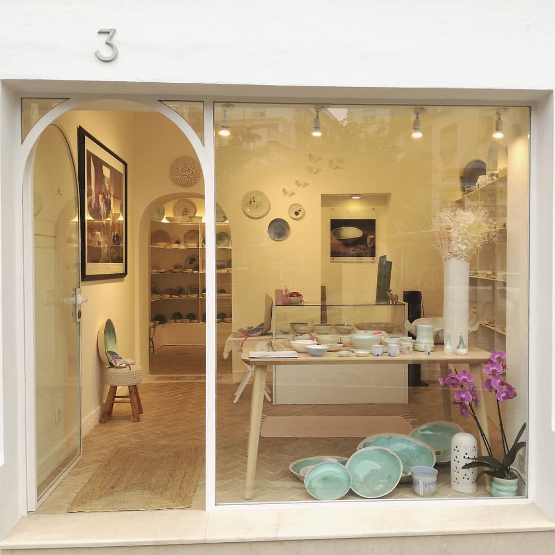 a window of a store with a table and plates