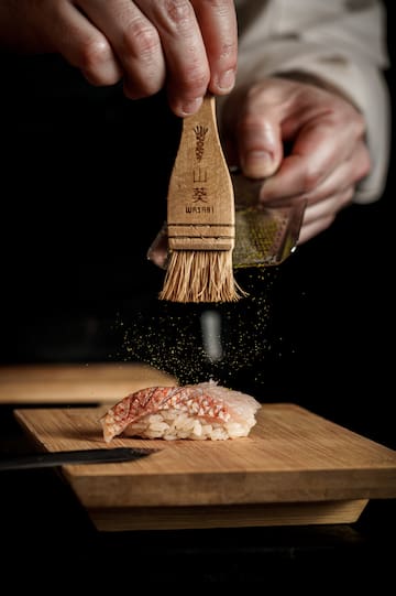 a person putting spices on a piece of food