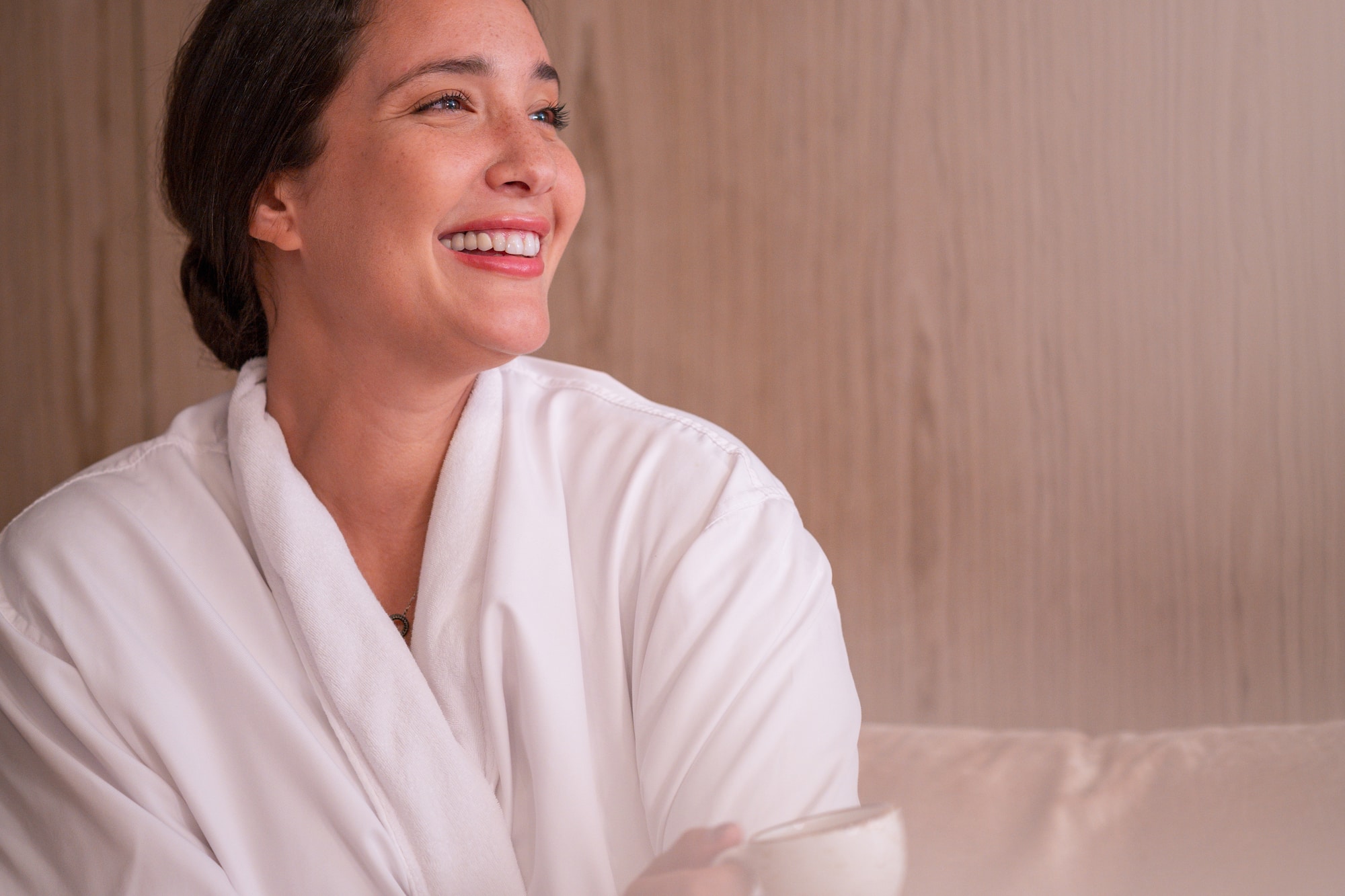 a woman in a white robe holding a cup